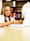 Girl in library with computer and globe