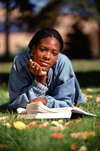 Girl reading book on lawn