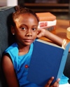 Young girl reading book in chair