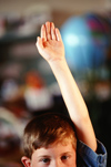 Young male student raising hand