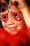 Boy looking through safety scissors