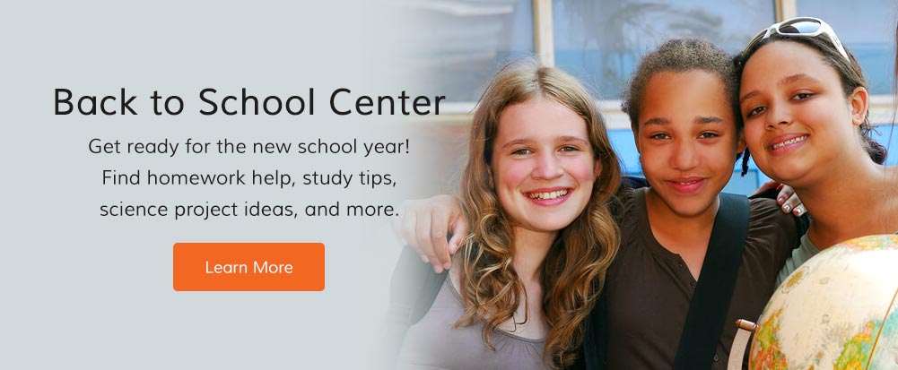 group of kids outside a school near a bus