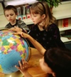 Two children looking at a globe