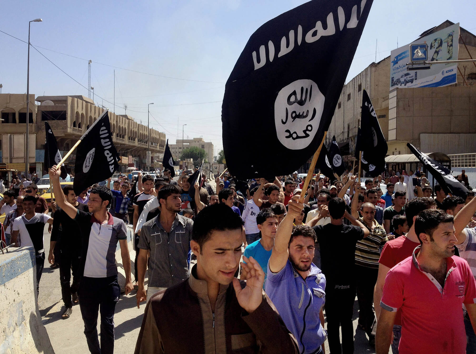 image of demonstrators carrying the Islamic State's flag