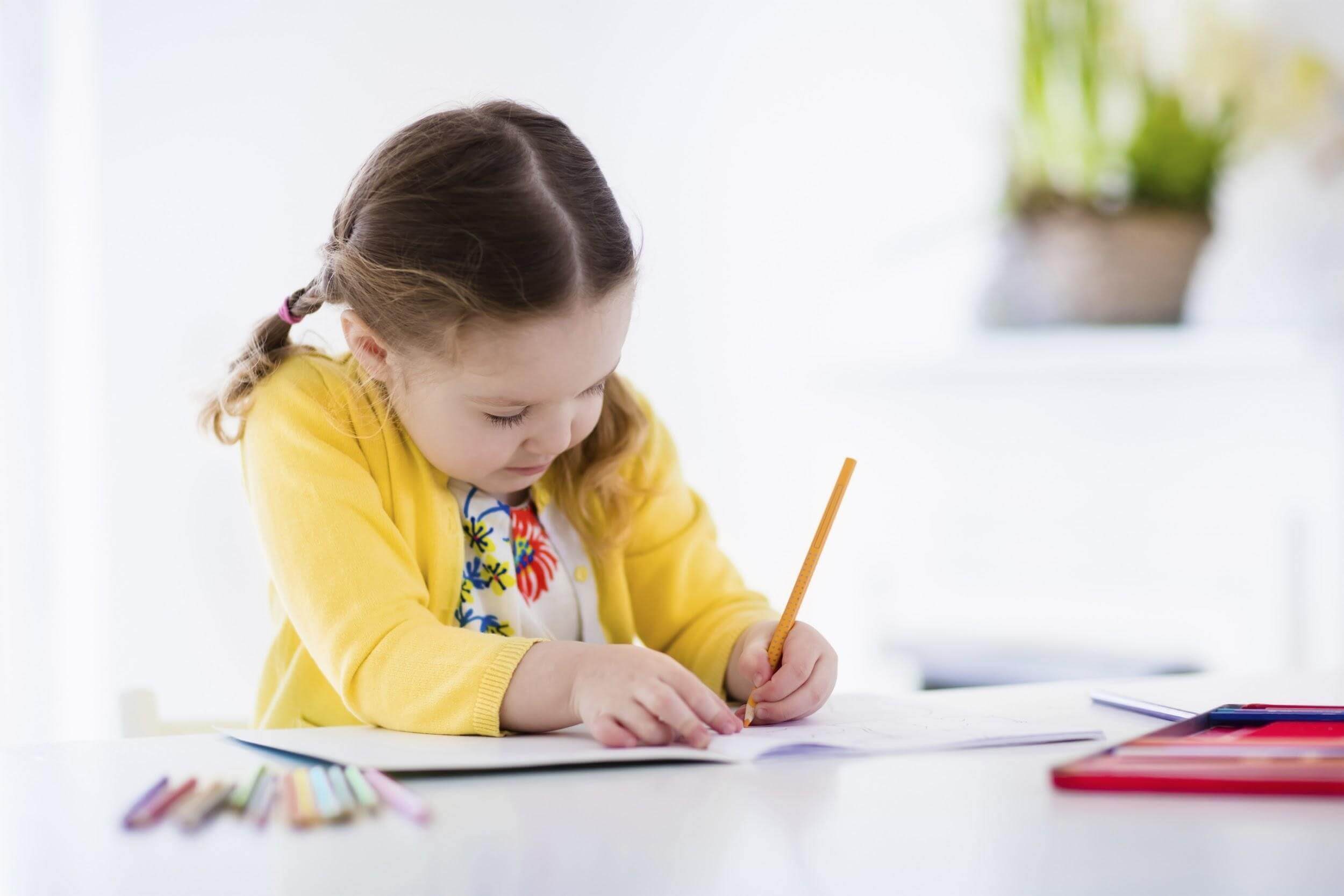 Young Girl Writing with Pencil at Table