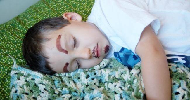 Sleeping Boy with Silly Face Drawn On In Marker