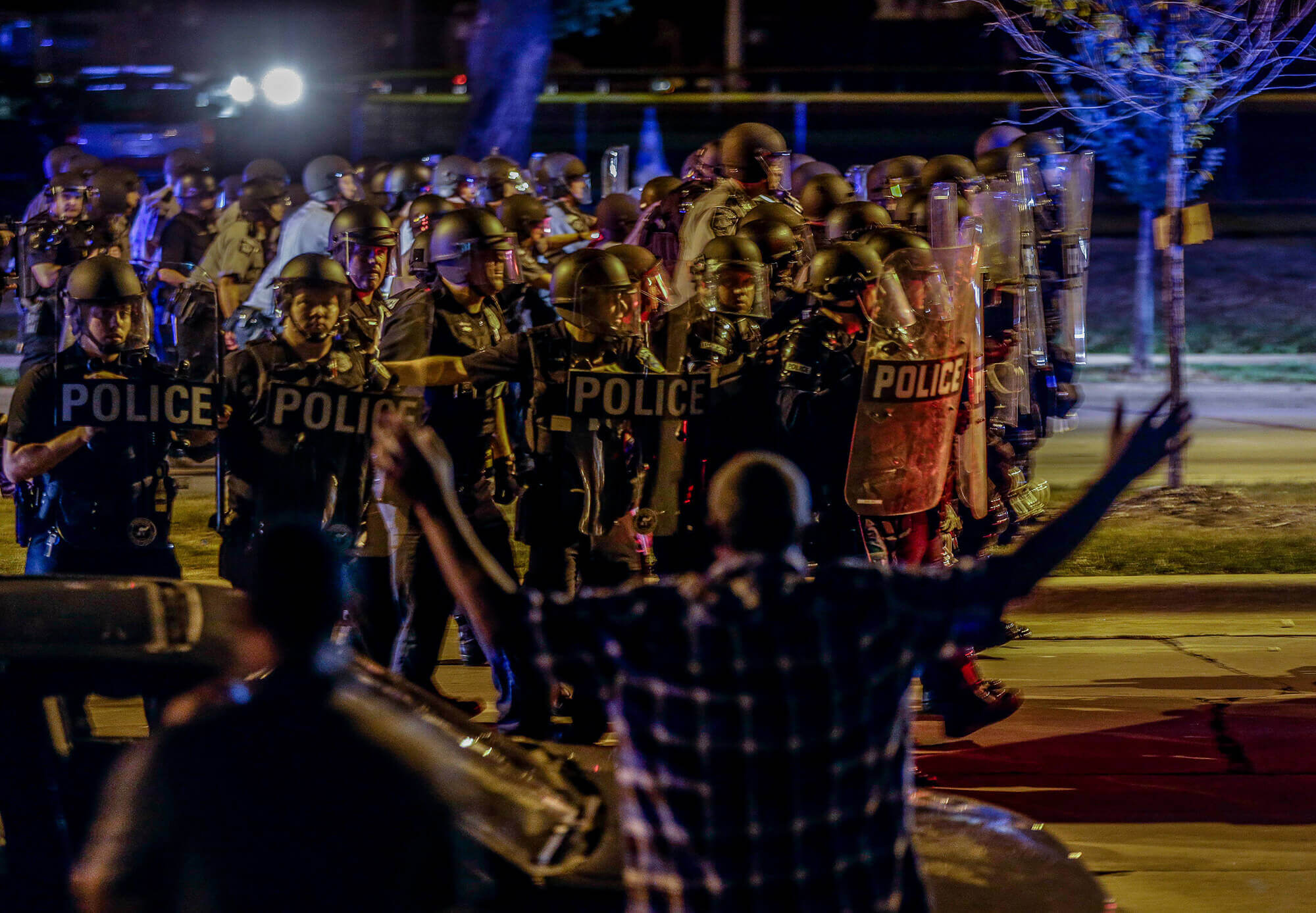 Image of police moving in on a group of protesters throwing rocks in Milwaukee