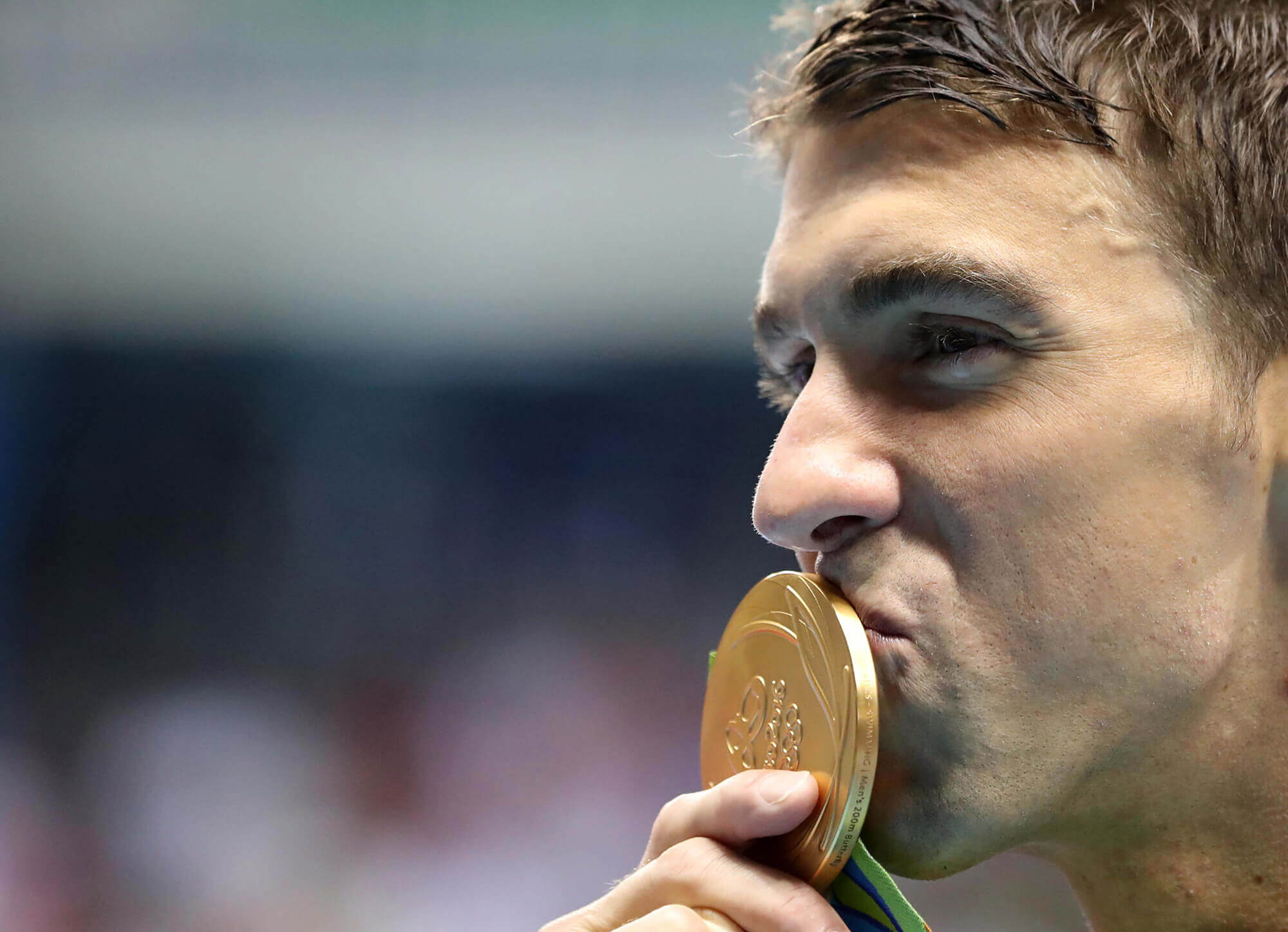 Image of Michael Phelps kissing his 20th gold medal